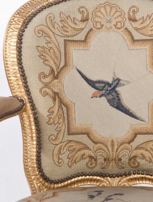 A hand stitched swallow decorates this restored open arm chair