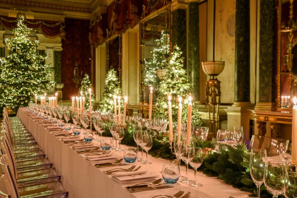 Dinner in the Gallery of Harewood House Leeds. A long table set up with candles and foliage