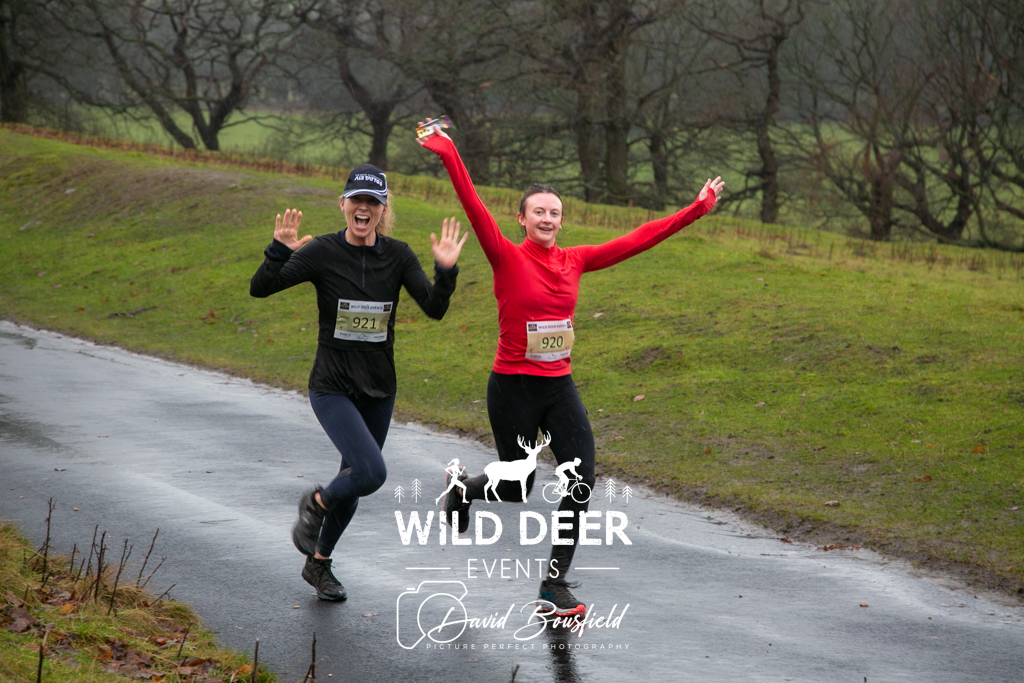 2 runners with their arms in the air running on road at Harewood House, Leeds