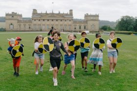 School children partaking in Saxon School Session at Harewood, running with home made shields at the camera.