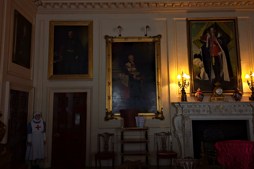 Dimmed lighting in the State Dining room with only two lamps glowing. In the corner stands a women dressed as a ghost Nurse from the war